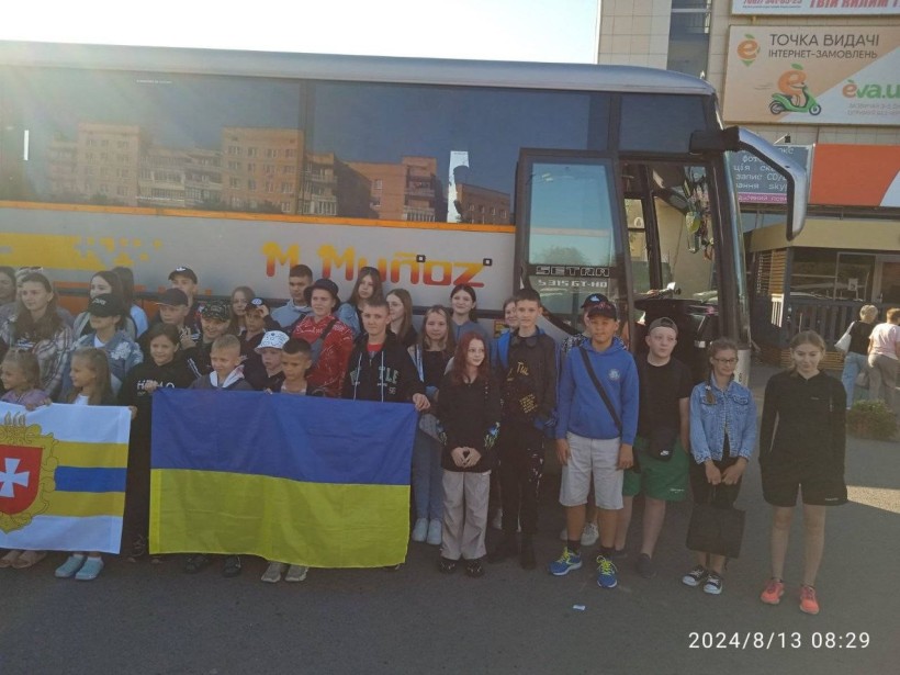 Діти Рівненщини, які поїхали на одоровлення, біля автобуса тримають в руках Державний Прапор України