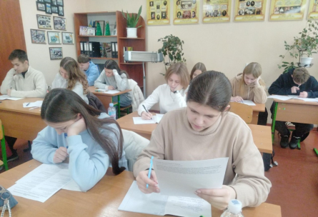 Фото ілюстративне - за партами сидять учні в класі та щось уважно читають і записують