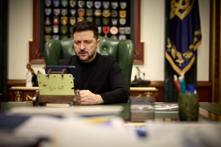 Президент України Володимир Зеленський сидить у своєму робочому кабінеті та спілкується по відеозв'язку