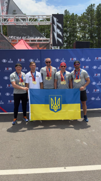 На фото -  переможці змагань. Стоять 5 чоловіків, у яких на грудях відзнаки, а в руках - прапор України
