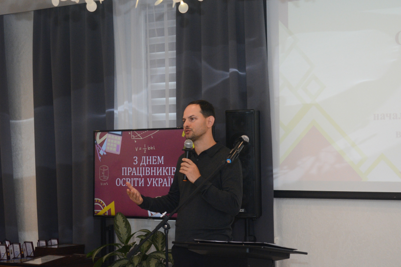 Олександр Коваль із мікрофоном у руках спілкується з освітянами області