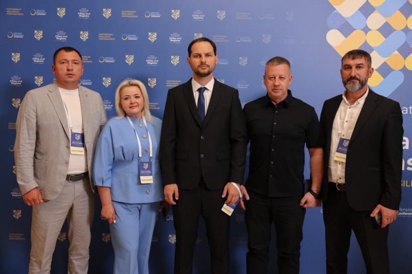 На загальному фото біля блакитного банера стоять 4 чоловіків та 1 жінка. В центрі - начальник Рівненської ОВА Олександр Коваль, решта - керівники - Великоомелянської, Рівненської, Гощанської та Корнинської громад.