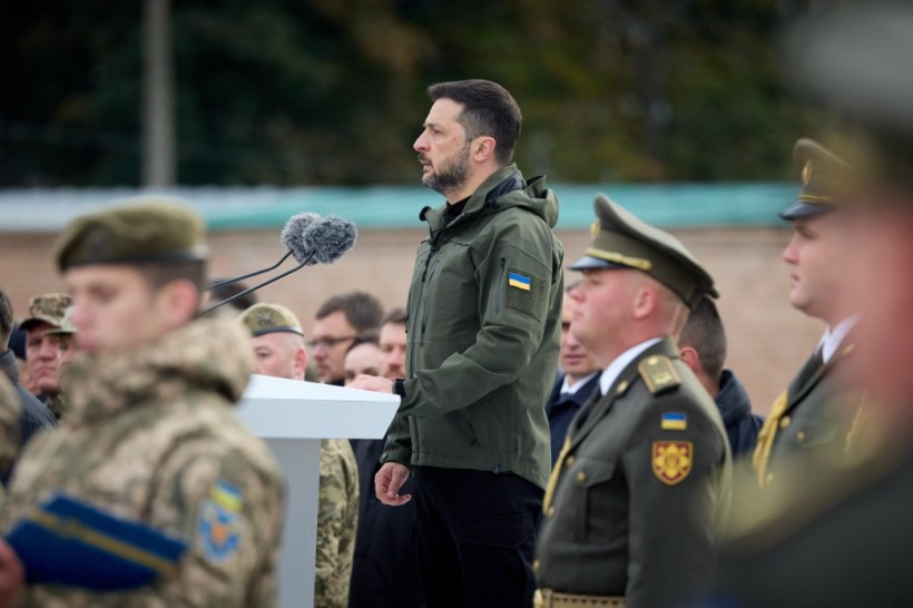 Президент України Володимир Зеленський під час урочистих заходів стоїть перед трибуною серед військових