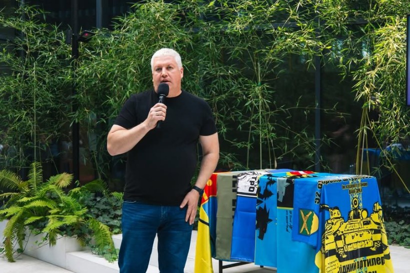 Заступник голови Рівненської ОДА з питань цифрового розвитку, трансформацій і цифровізації (CDTO) Олександр Терещенко з мікрофоном у руках вітає нотаріусів Рівненщини