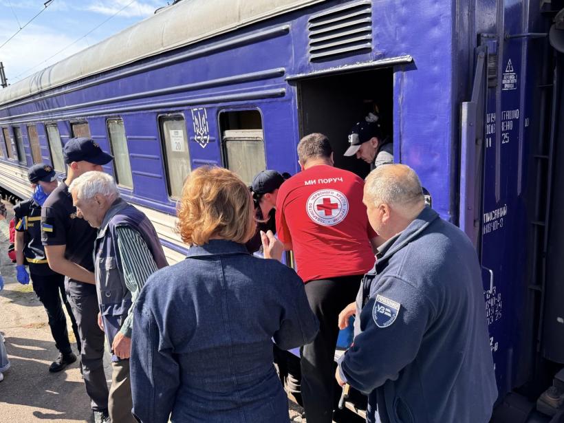 З поїзда виводять людину представники Червоного хреста, ДСНС, інших служб.