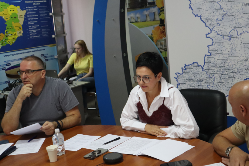 Заступниця голови Рівненської ОДА Людмила Шатковська під час онлайн наради. Вона сидить за столом та дивиться на монітор, поруч з нею інші учасники наради