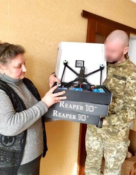 На фото Валентина Осадчук передає дрон військовому