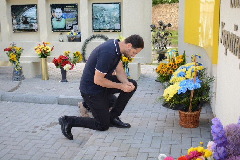 Начальник Рівненської ОВА Олександр Коваль стоїть на одному коліні біля стіни пам'яті