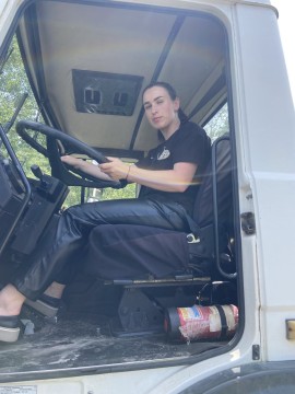 На фото жінка сидить за кермом багатотонажного грузового автомобіля
