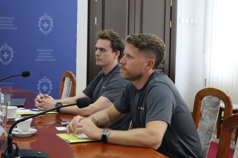Представники з Великої Британії, два молодих чоловіки, сидять за столом та дивляться на керівництво області