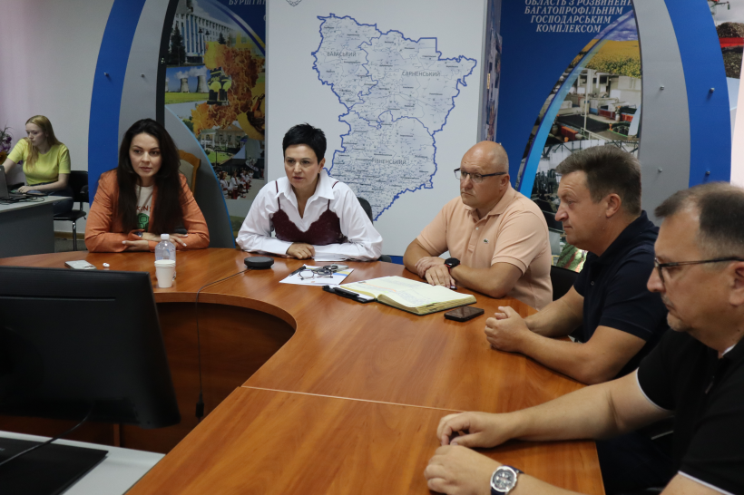 Заступниця голови Рівненської ОДА Людмила Шатковська проводить нараду. За столом з нею сидять да дивляться на монітор: начальниця Управління з питань ветеранської політики Марина Корольова, голова Рівненської РДА Юрій Колос, Городоцький сільський голова Сергій Поліщук та начальник Управління соціального захисту Рівненської РДА Вадим Максютинський