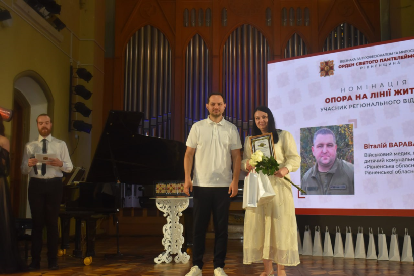 Начальник Рівненської ОВА Олександр Коваль вручає нагороду медикині