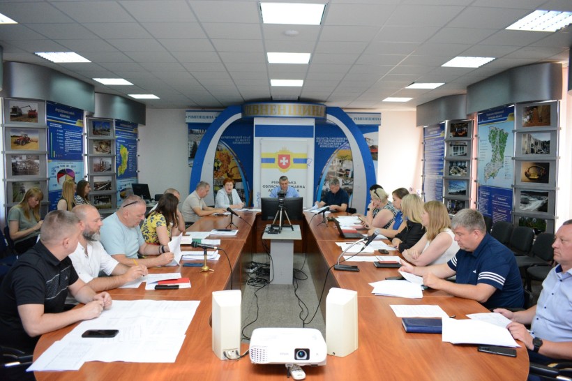 На фото учасники зустрічі сидять за столом та спілкуються