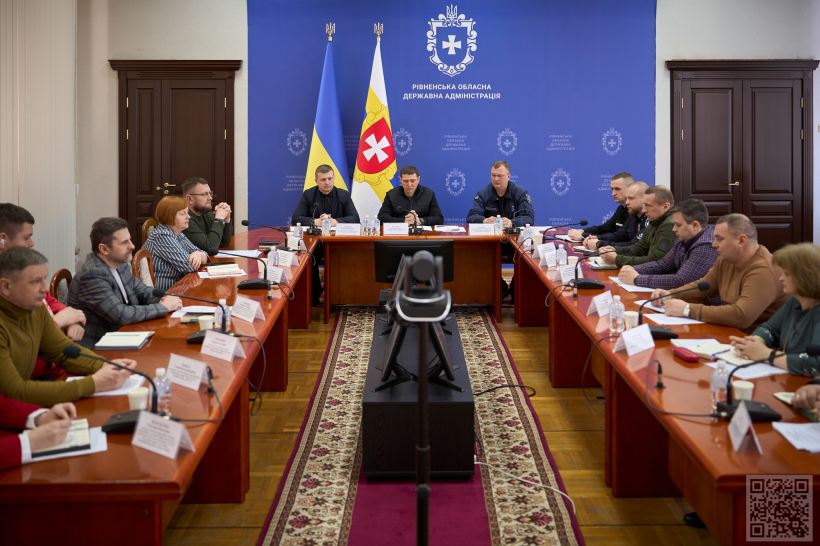 У залі Рівненської обласної державної адміністрації проходить засідання Державної комісії з питань техногенно-екологічної безпеки та надзвичайних ситуацій. За квадратним столом сидять багато учасників (приблизно 20 осіб), які є представниками різних служб та управлінь. На головному місці сидить перший заступник голови Рівненської ОДА Сергій Подолін, який проводить засідання комісії. Всі зосереджені та спілкуються між собою