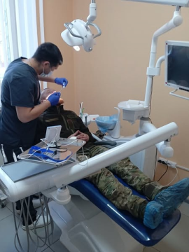 Фото ілюстративне - на ньому військовий лежить у стоматологічному кріслі, а лікар йому лікує зуби