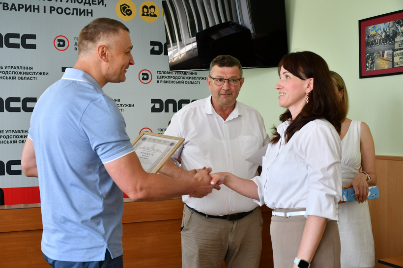 Заступник голови Рівненської ОДА Олександр Кохан вручає грамоту працівниці ветеринарії. Вона тисне руку заступнику голови ОДА та посміхається