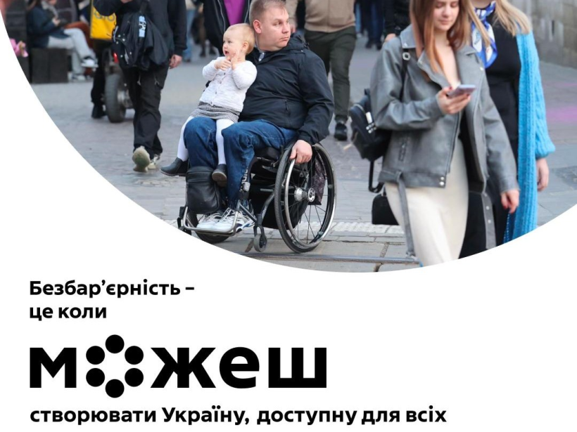 Фото ілюстративне - на ньму зображена вулиця якою йдуть багато людей. На центральному плані - чоловік на кріслі колісному та на колінах в нього сидить маленька дитина. Знизу підпис: безбар'єрність - це коли можем створити Україну, доступну для всіх