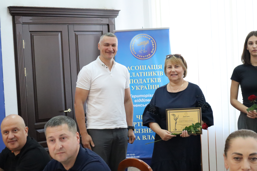 Олександр Кохан вручає грамоту підприємиці