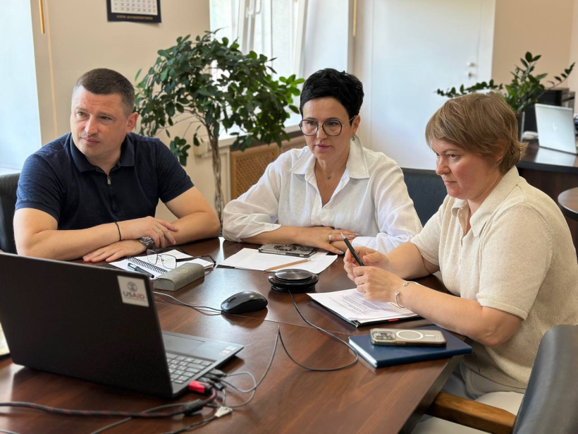 Онлайн-нарада під головуванням заступниці голови Рівненської ОДА Людмили Шатковської. За столом сидять троє осіб та уважно дивляться у монітор ноутбука