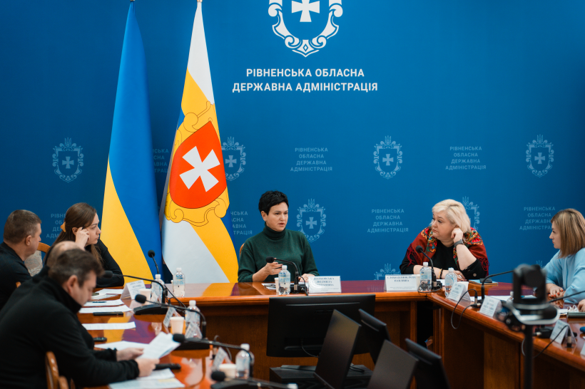 За столом сидять члени комісії та обговорюють документи