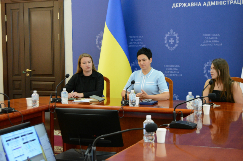 Заступниця голови Рівненської ОДА Людмила Шатковська та представники структурних підрозділів ОДА під час наради сидять за столом та уважно слухають і дивляться на монітор