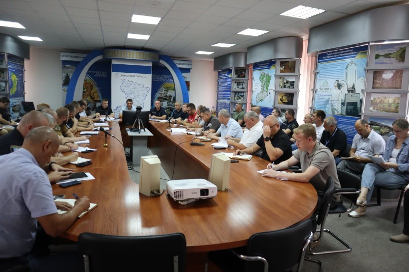 В залі проходить засідання комісії, всі учасники вивчають документи, які лежать перед ними