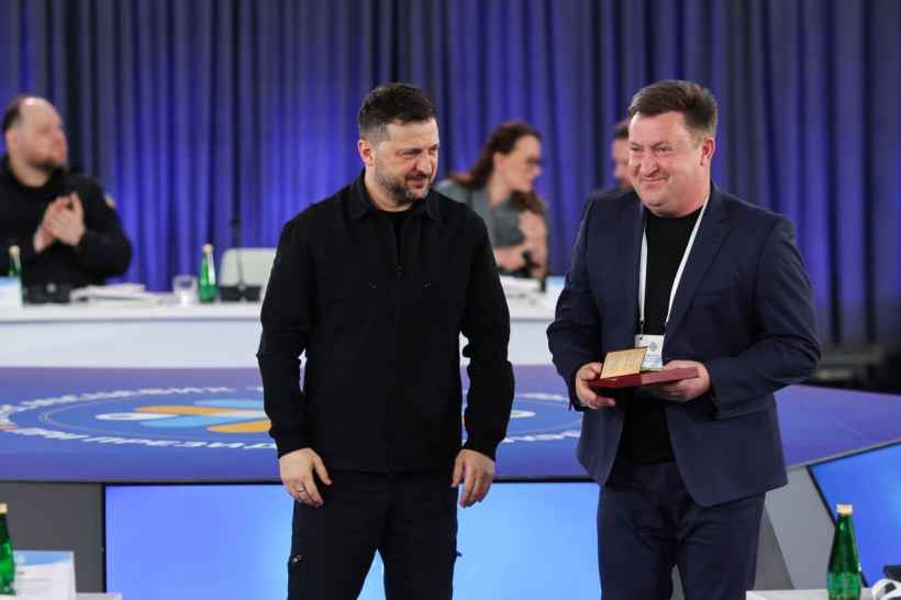 Президент України Володимир Зеленський вручає нагороду Городоцькому сільському голові Сергію Подоліну