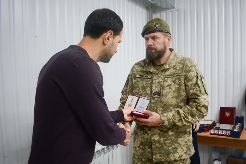 Олександр Коваль вручає нагороду військовослужбовцю Збройних Сил України
