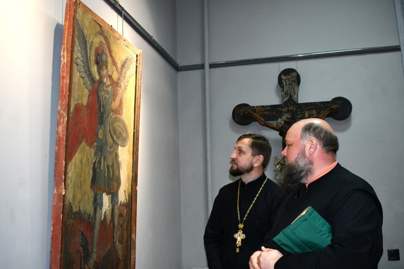 Виставка до Дня Української Державності: на стіні ікона, яку роздивляються двоє священників