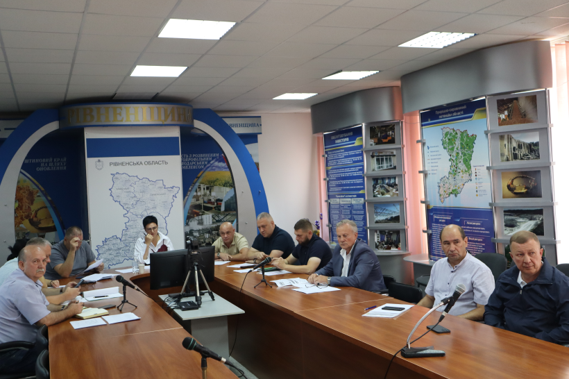 Заступниця голови Рівненської ОДА Людмила Шатковська та інші учасники урядової  наради сидять за столом, дивляться на монітор та уважно слухають