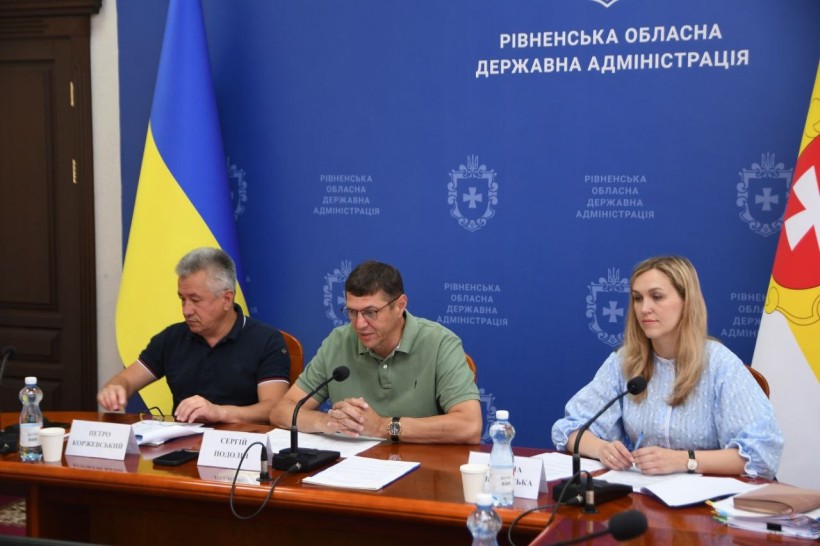 Директор департаменту освіти і науки ОДА П.Коржевський, перший заступник голови ОДА С.Подолін, заступниця директора департаменту освіти і науки ОДА М.Пашковська - під час наради за столом на фоні банера Рівненської обласної державної адміністрації