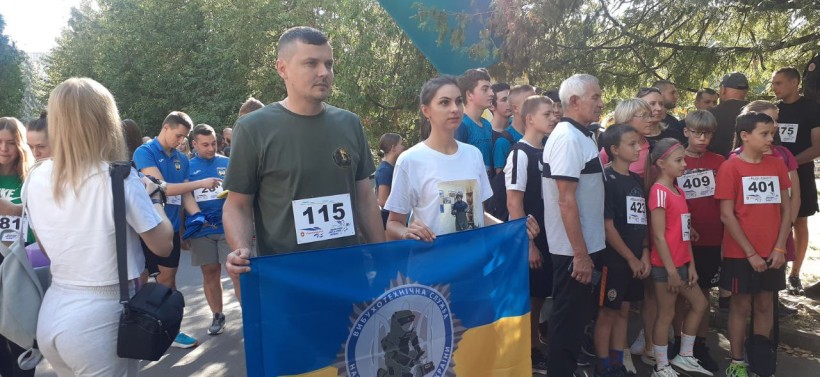 Учасники забігу фотографуються із прапором