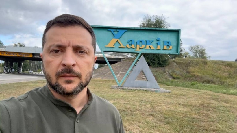 Президент України Володимир Зеленський стоїть на узбіччі біля знаку "Харків"