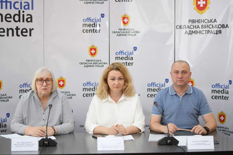 Спікери брифінгу: директорка Рівненського обласного центру служби крові Ліна Михальчук, заступниця гендиректора Рівненського обласного центру контролю та профілактики хвороб Олена Гашовська, радник голови ОДА Сергій Татаренко на фотні банера медіацентру Рівненської ОДА
