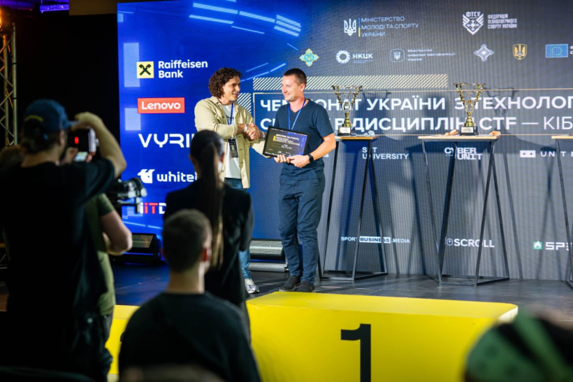 Організатор змагання вручає на сцені командиру диплом
