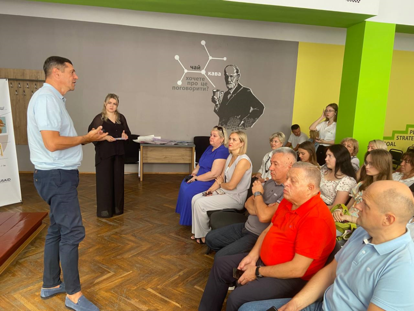 Перший заступник голови Рівненської ОДА Сергій Подолін виступає перед аудиторією, всі сидять слухають, він говорить та  активно жестикулює