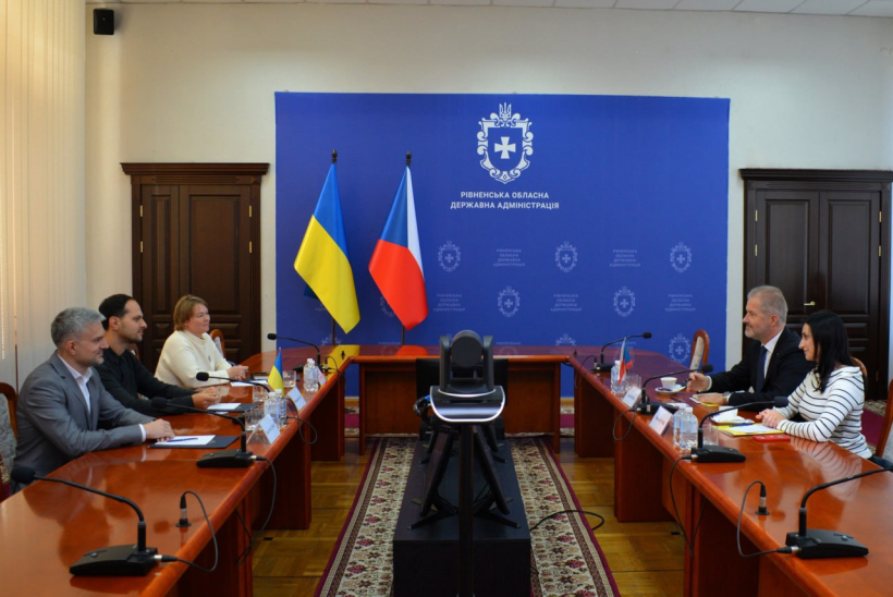 Учасники зустрічі сидять за столом та спілкуються