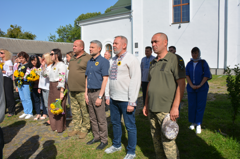 Представники обласної та районної влади, рідні полеглих воїнів, силовики, військові, духовенство та волонтери стоять під час урочистостей