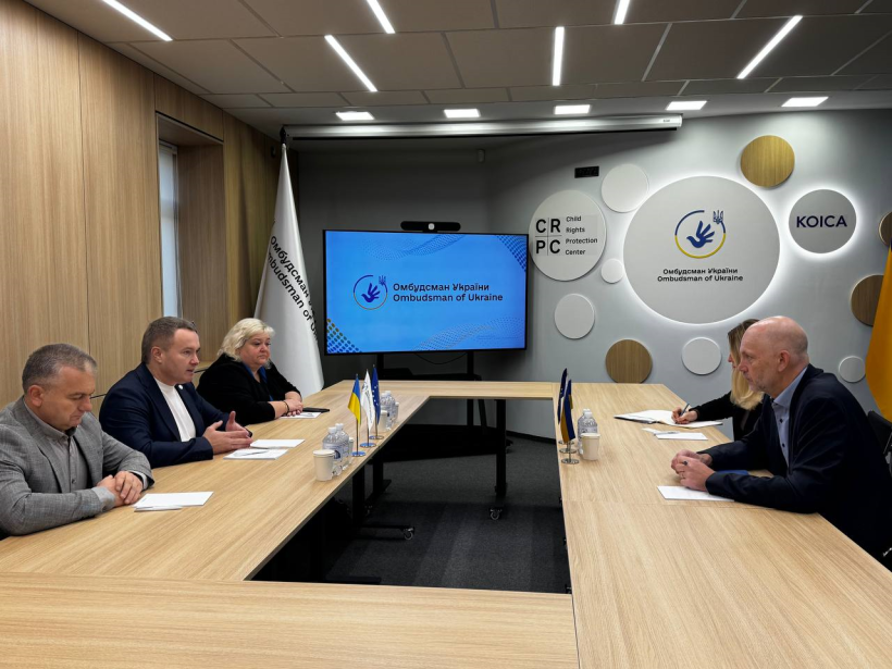 Учасники зустрічі сидять за столом та спілкуються