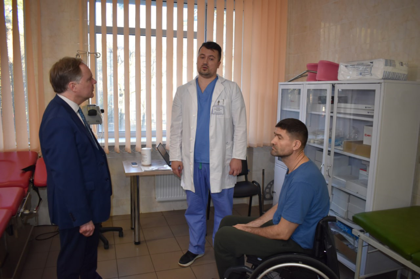 Посол Великої Британії в Україні Мартін Гарріс спілкується з лікарем та військовослужбовцем, який проходить реабілітацію у госпіталі