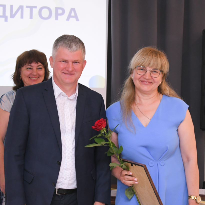 Начальник Департаменту економічного розвитку і торгівлі ОДА Костянтин Мокляк вручає грамоту бухгалтерці. Обоє усміхнені
