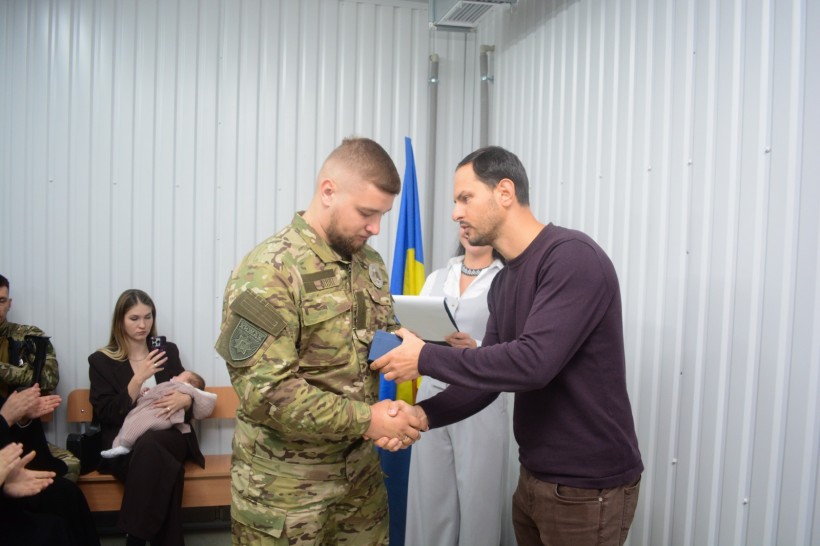 Олександр Коваль вручає нагороду військовослужбовцю Збройних Сил України