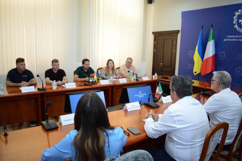 У приміщенні ОДА за столом сидять начальник Рівненської ОВА Олександр Коваль, голова обласної ради Андрій Карауш, інші керівники структурних підрозділів ОДА. З іншого боку круглого столу сидять лікарі з Італії