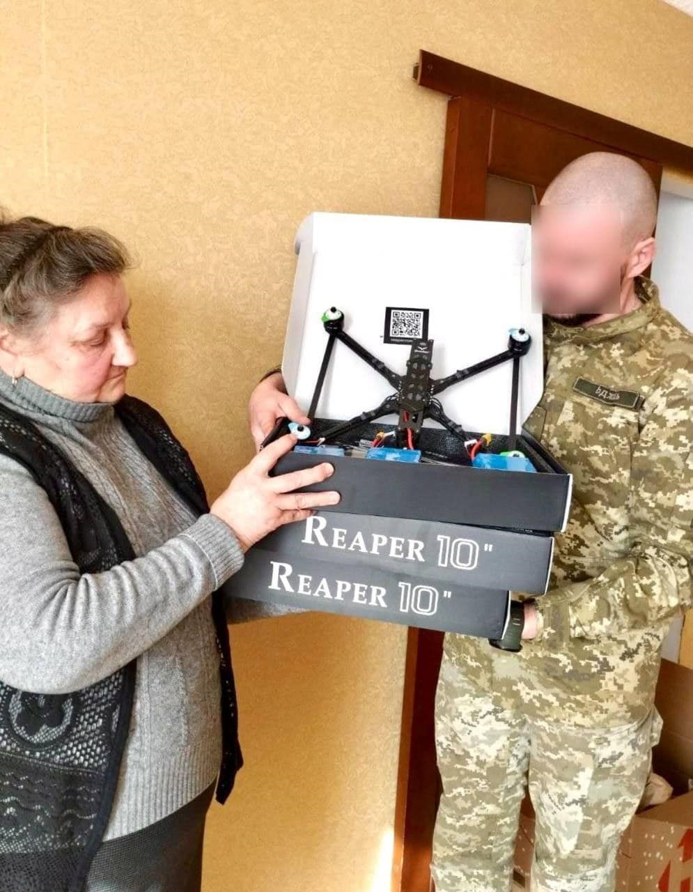 На фото Валентина Осадчук передає дрон військовому