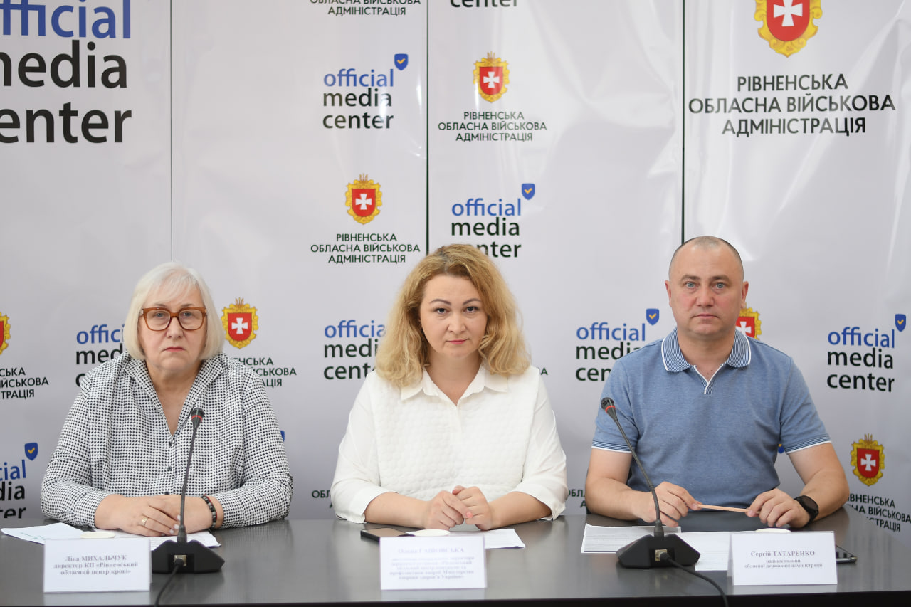 Спікери брифінгу: директорка Рівненського обласного центру служби крові Ліна Михальчук, заступниця гендиректора Рівненського обласного центру контролю та профілактики хвороб Олена Гашовська, радник голови ОДА Сергій Татаренко на фотні банера медіацентру Рівненської ОДА