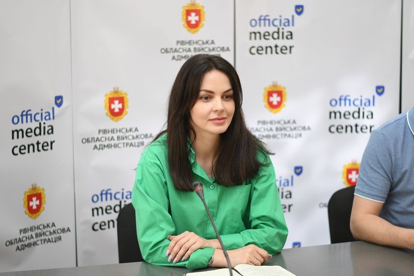 Заступниця директорки Департаменту соціальної політики - начальниця управління у справах ветеранів Рівненської ОДА М.Корольова на фоні банера медіацентру Рівненської обласної державної адміністрації