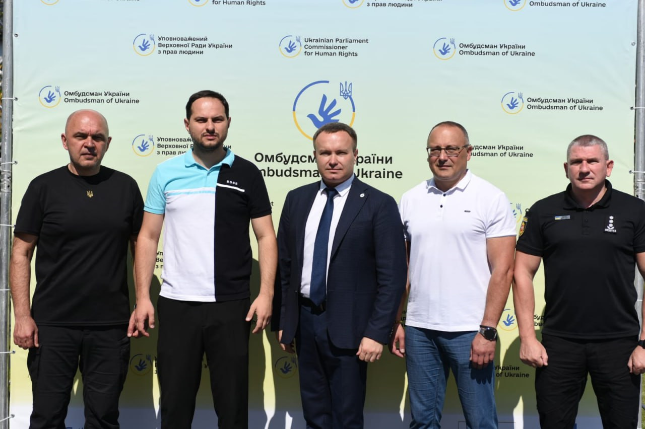 Олександр Коваль з колегами на фоні банера