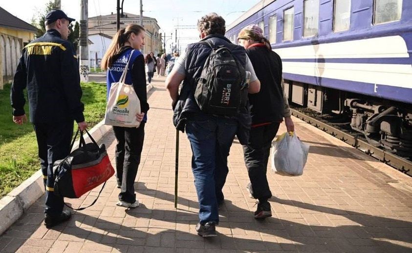 Люди з речами біля вагону на залізничому вокзалі