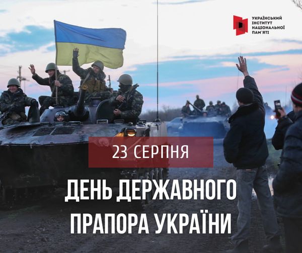 Зображення присвячене Дню Державного Прапора України, який відзначається 23 серпня. На зображенні видно українських військових, що їдуть на бронетехніці та тримають у руках український прапор. На передньому плані люди вітають їх, піднімаючи руки. На зображенні також є логотип Українського інституту національної пам'яті.