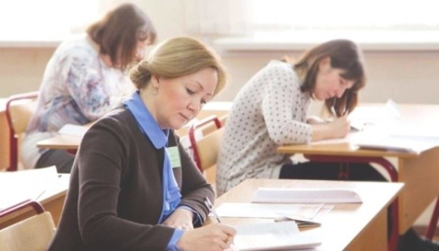 Три жінки в аудиторії роблять записи. Фото ілюстративне